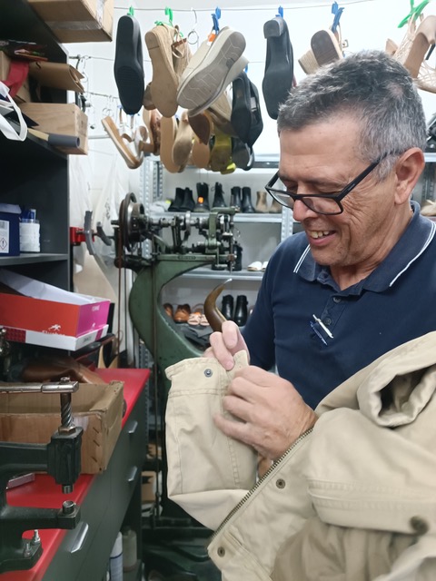 Miguel adding a snap-on button to a jacket.. Photo © Karethe Linaae